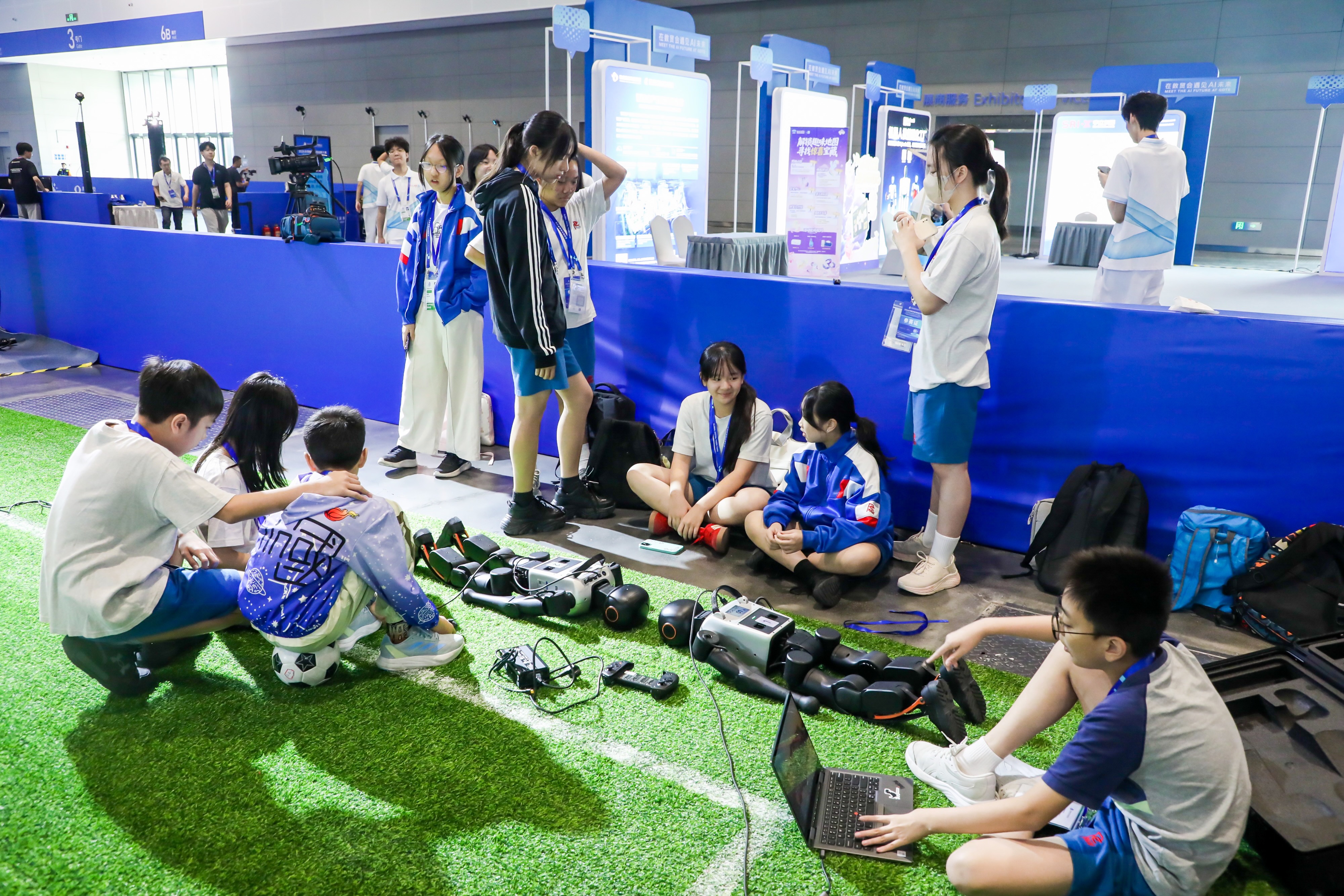 Students tuning the robots beside the pitch